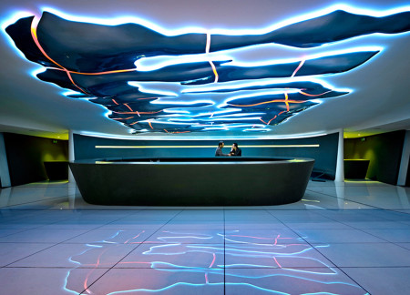 Kinetic Light Play Within Glass and Metal Forms in a Cultural Bar Setting