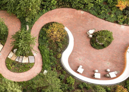 Natural Stone Pathways and Clay Brick Seating Integrated into Sustainable Community Space