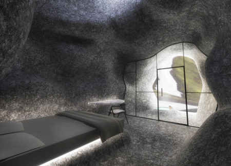 Local Stone and Glass Fiber Panels Create Camouflaged Community Gathering Space