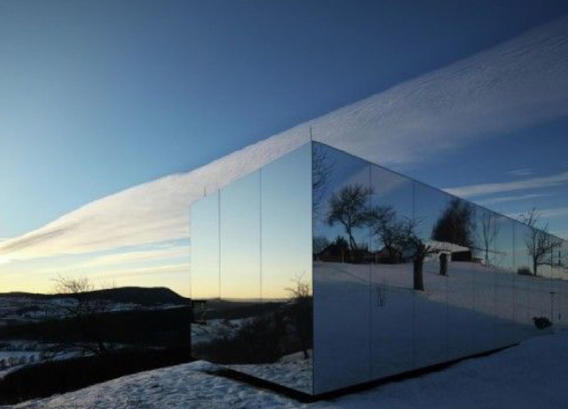 Reflective Steel Cladding and Charred Wood Define a Serene Meditation Retreat